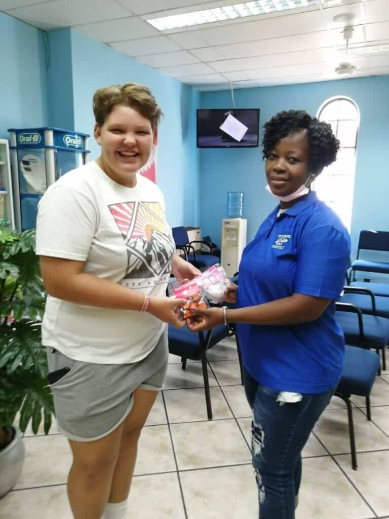 Cheerful patient receiving dental care supplies from friendly dental professional in South Africa.