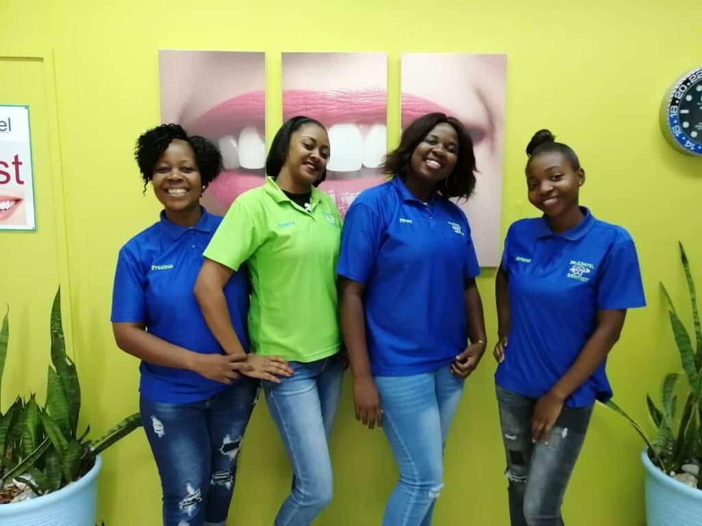 Smiling dental team in colourful uniforms at DrSPateldentist clinic.