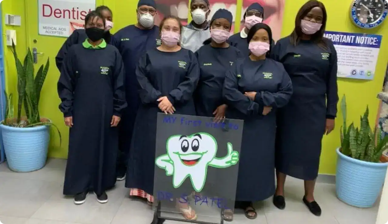 Drspateldentist-team-in-scrubs-wearing-masks-standing-with-dental-gear, alt text,.